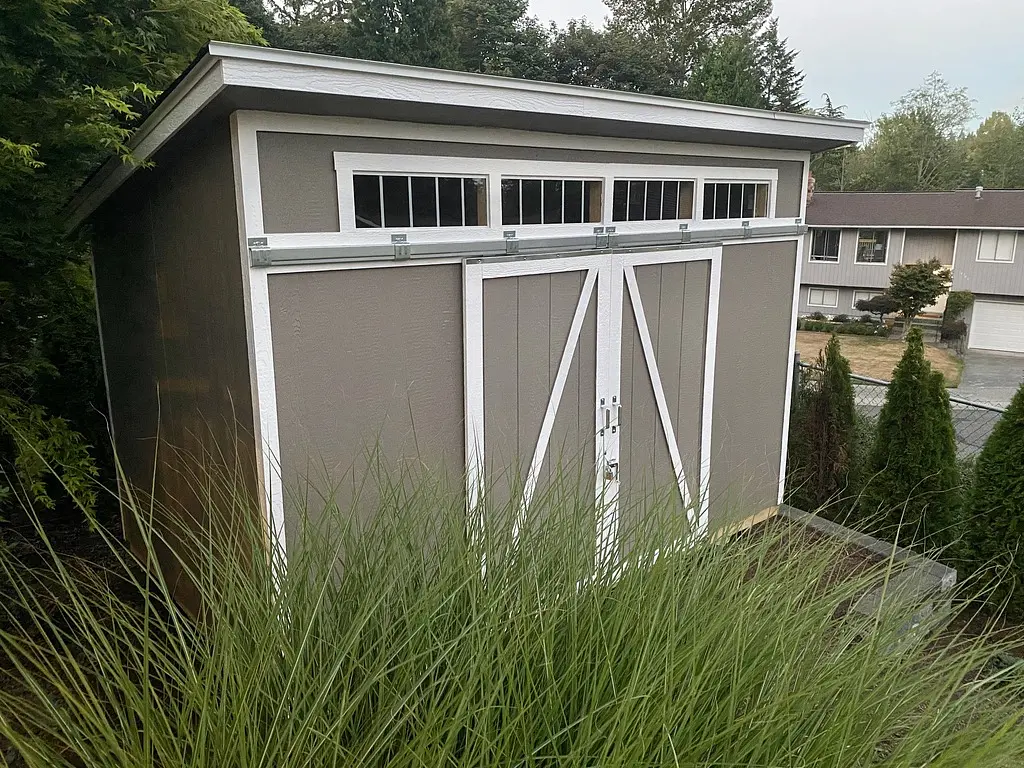 Shed behind some grass.
