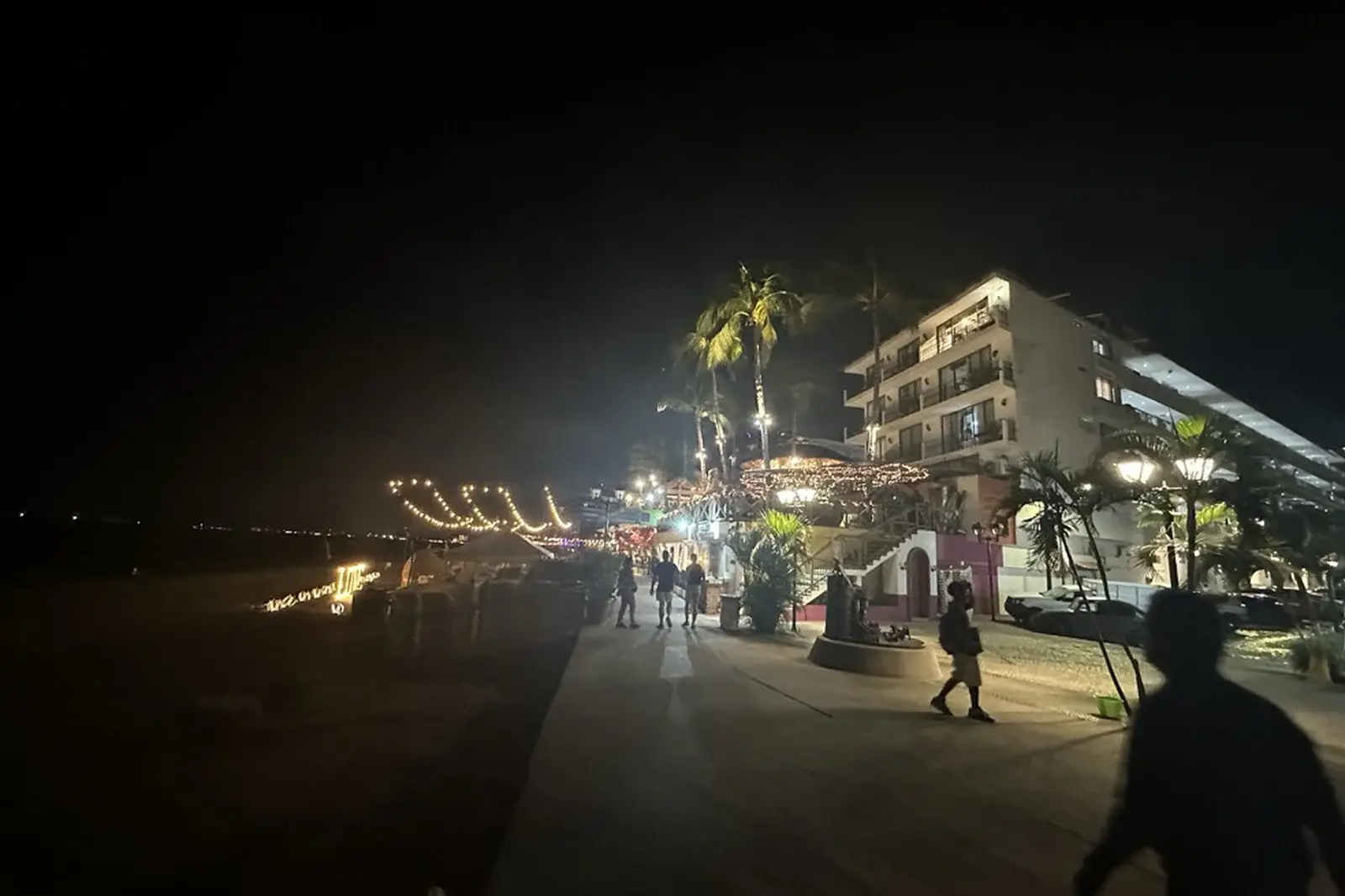 A photograph of the boardwalk along the beach at night.