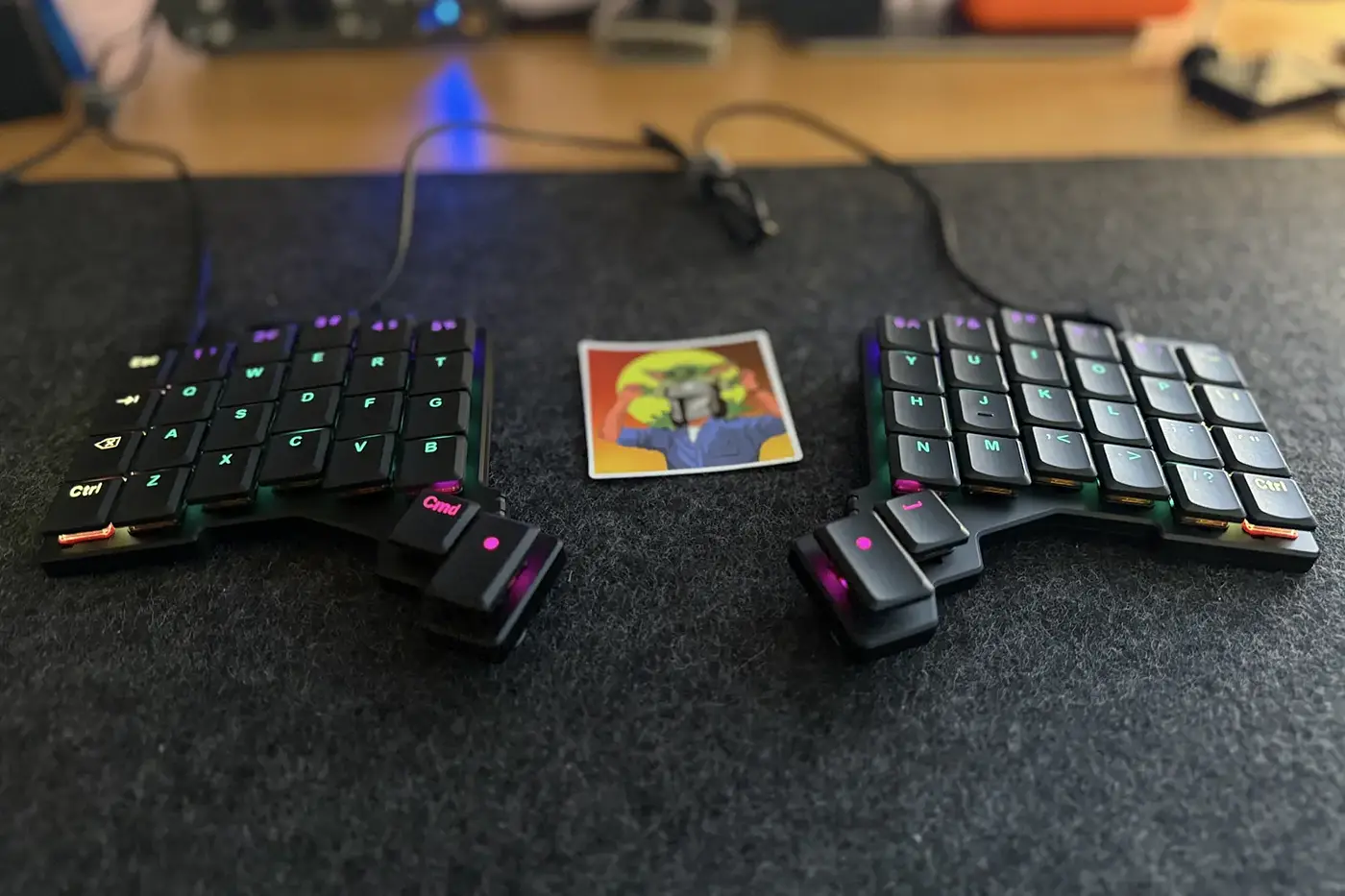 A photo of a black ZSA Voyager keyboard sitting on a felt desk mat.